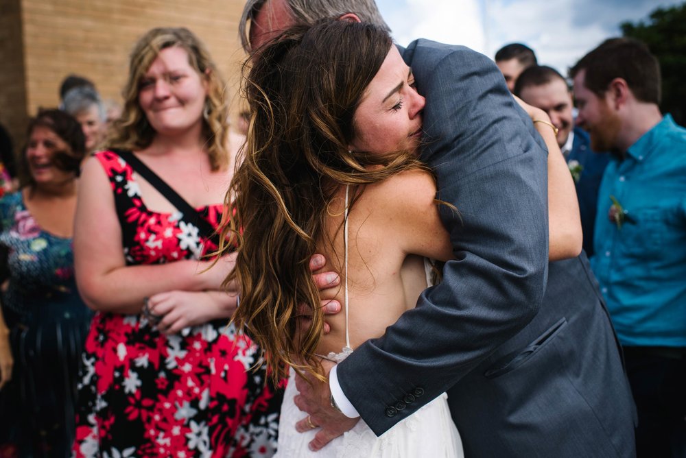 Bride hugs father after wedding service