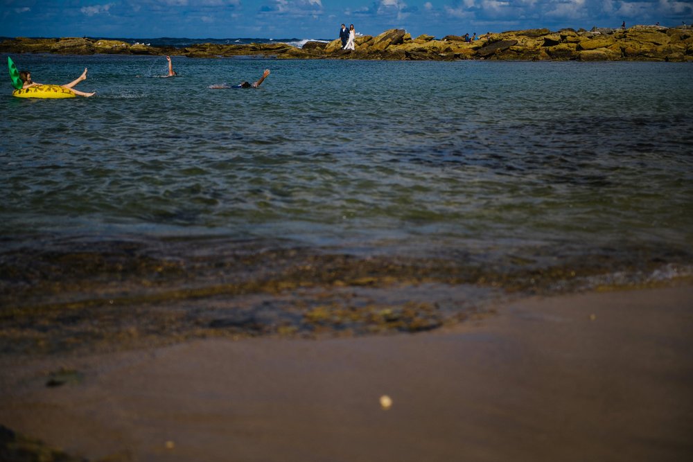 Landscape view of Little Bay, NSW with the bride and groom on the horizon