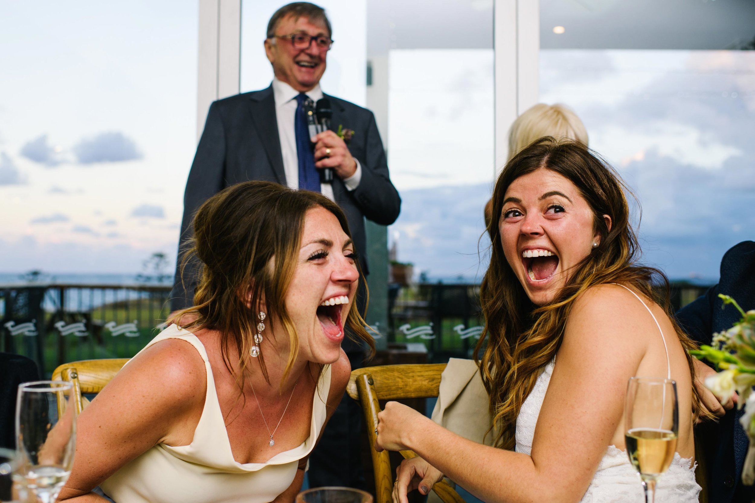 Bride and sister laughing at Coast Golf Club reception