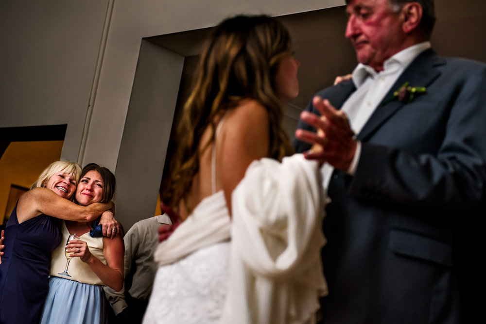 Mother and sister look on during father-daughter dance