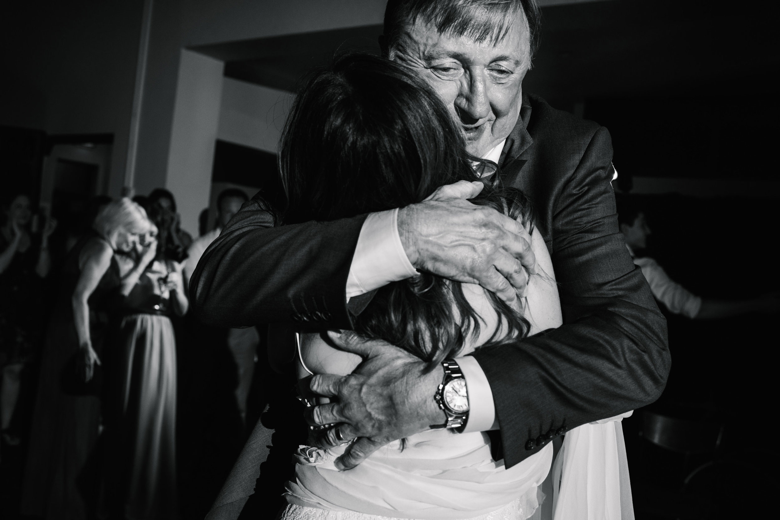 Father hugging daughter and looking emotional during dance