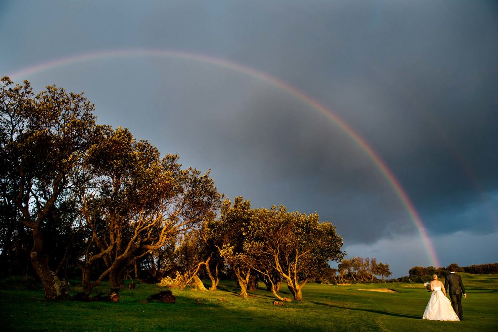 Bride and groom under a rainbow on Long Reef Golf course