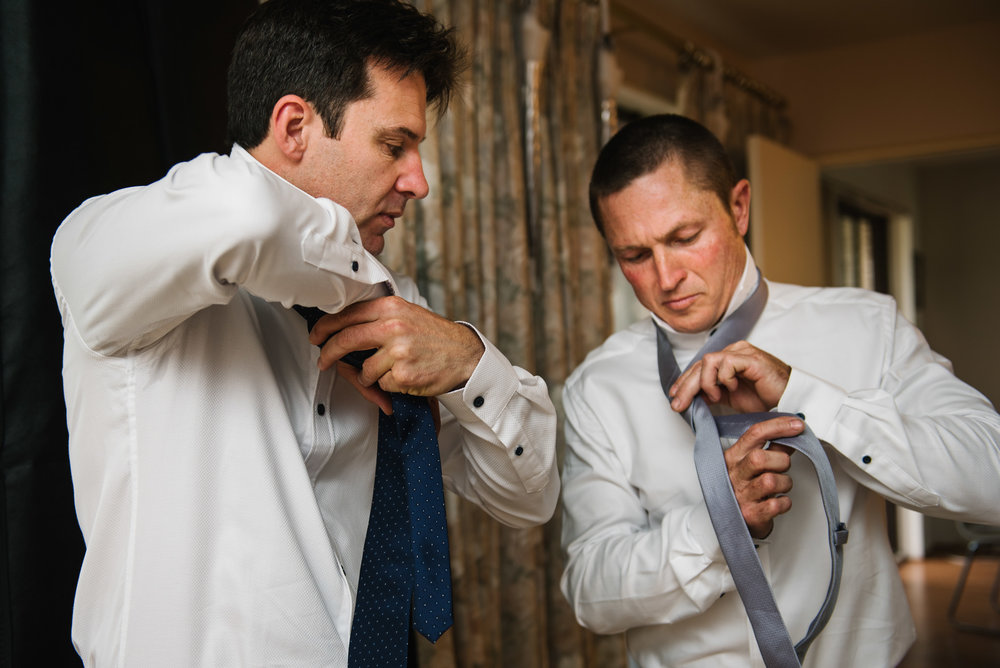 Groom and groomsmen tying ties