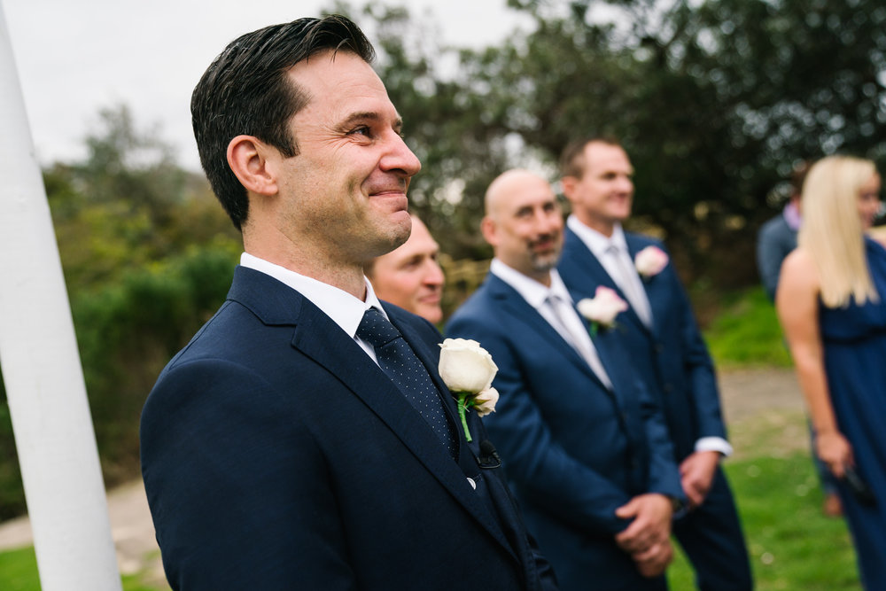 Groom tearing up as bride walks down the aisle toward him at Shelly Beach wedding