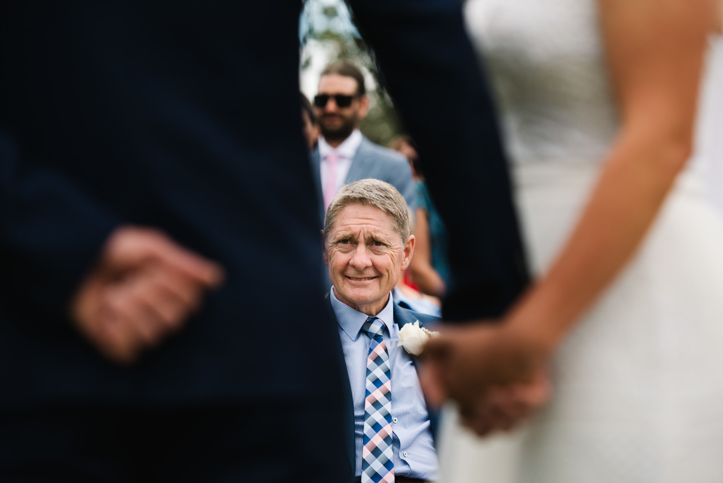 Father of the bride smiling during ceremony
