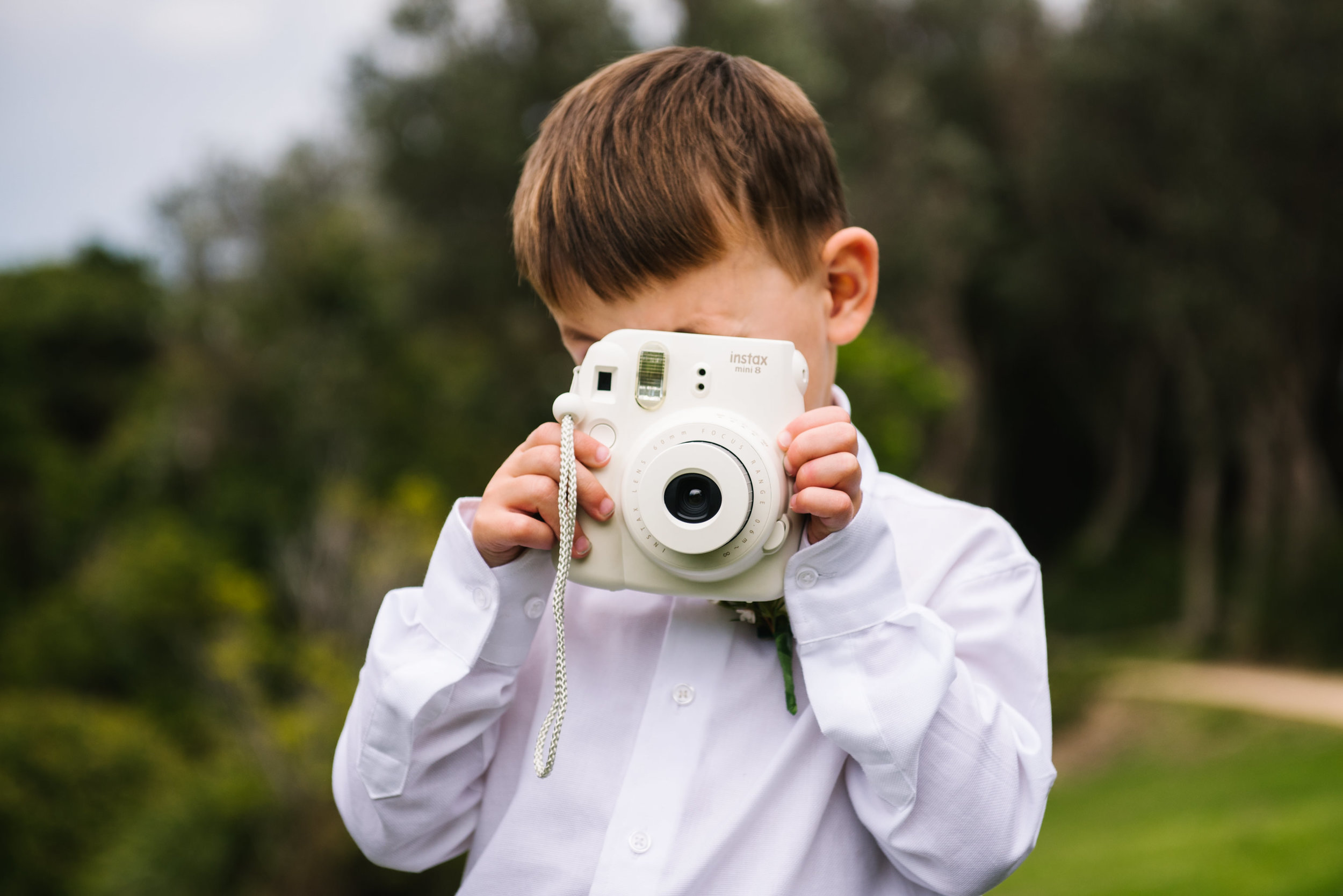 Ringbearer taking photo with an instax polaroid camera