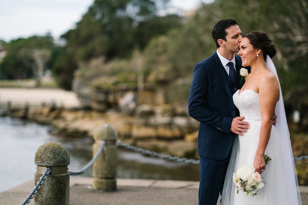 Newlyweds posing in front of Little Manly Beach