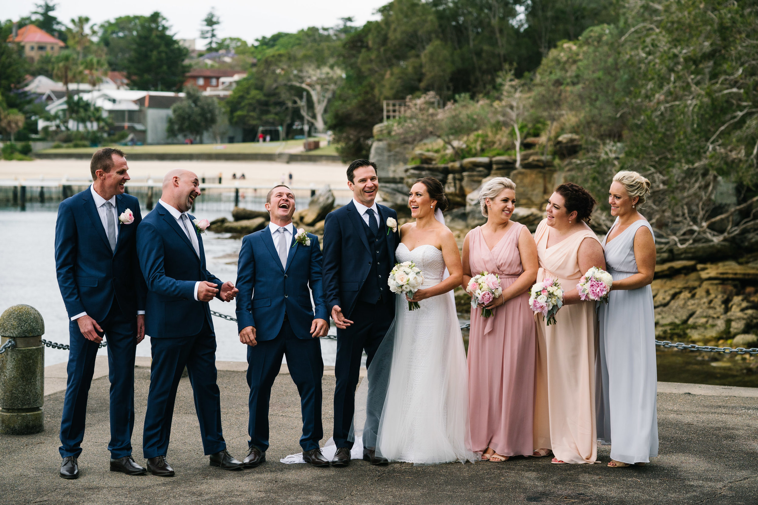 Bridal party laughing with Little Manly Beach in the backdrop
