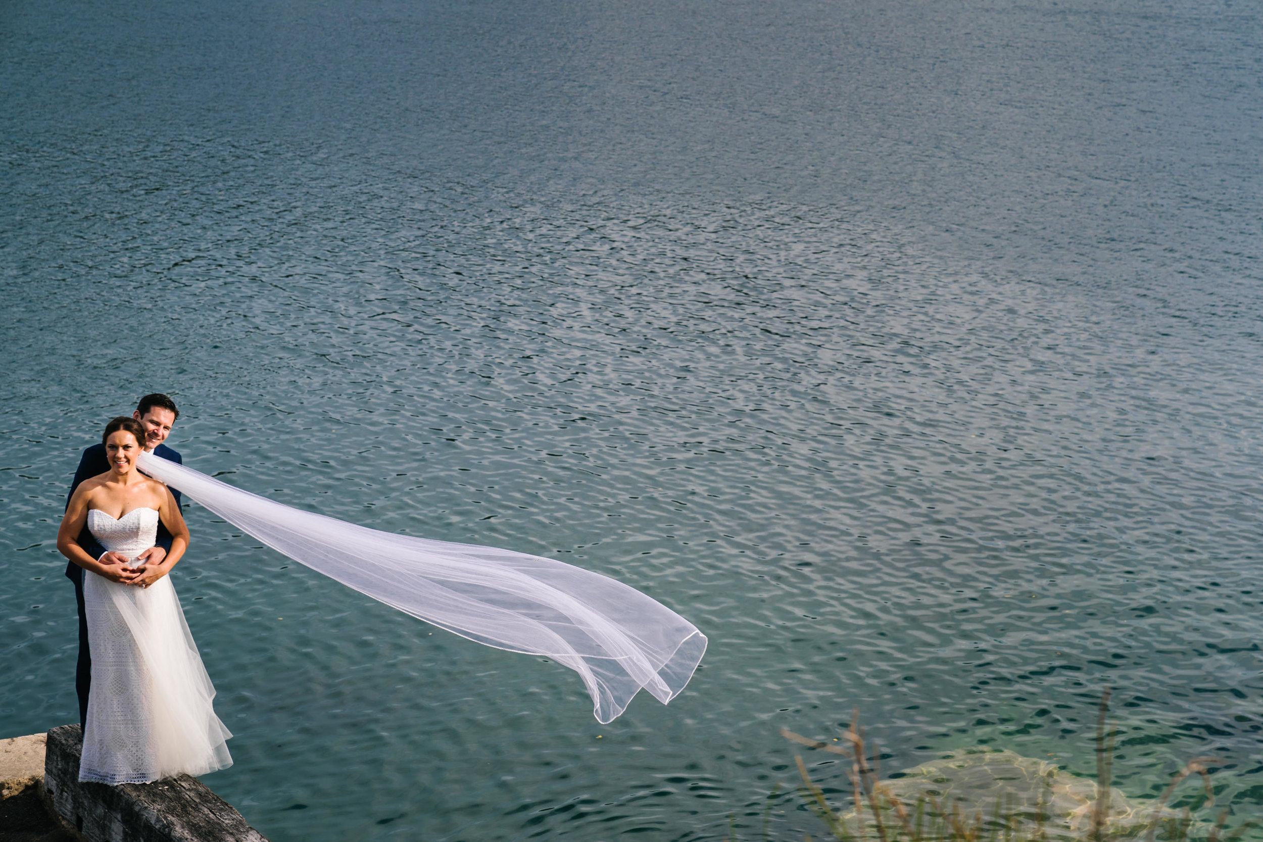 Bride's veil flowing in the wind with ocean in the backdrop
