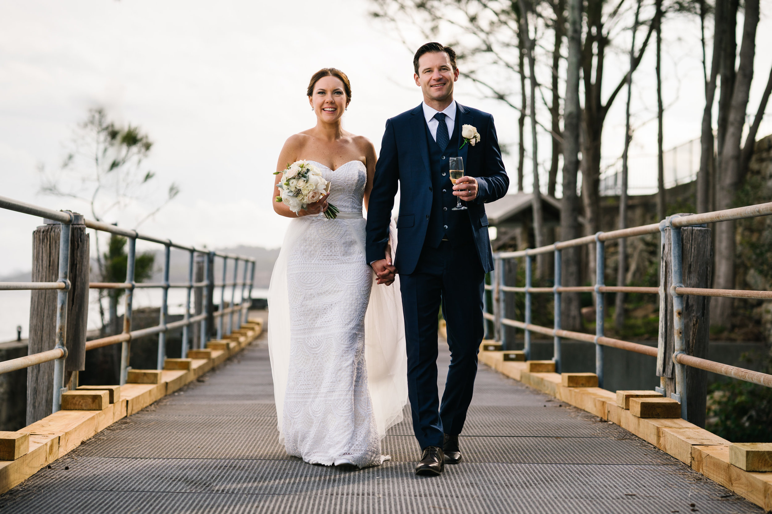 Newlyweds walking over bridge at Little Manly Beach 