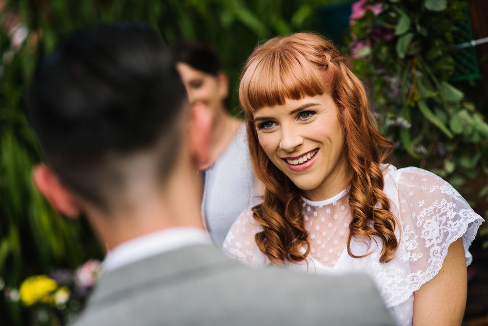 Bride smiles at groom during garden wedding ceremony in Sydney