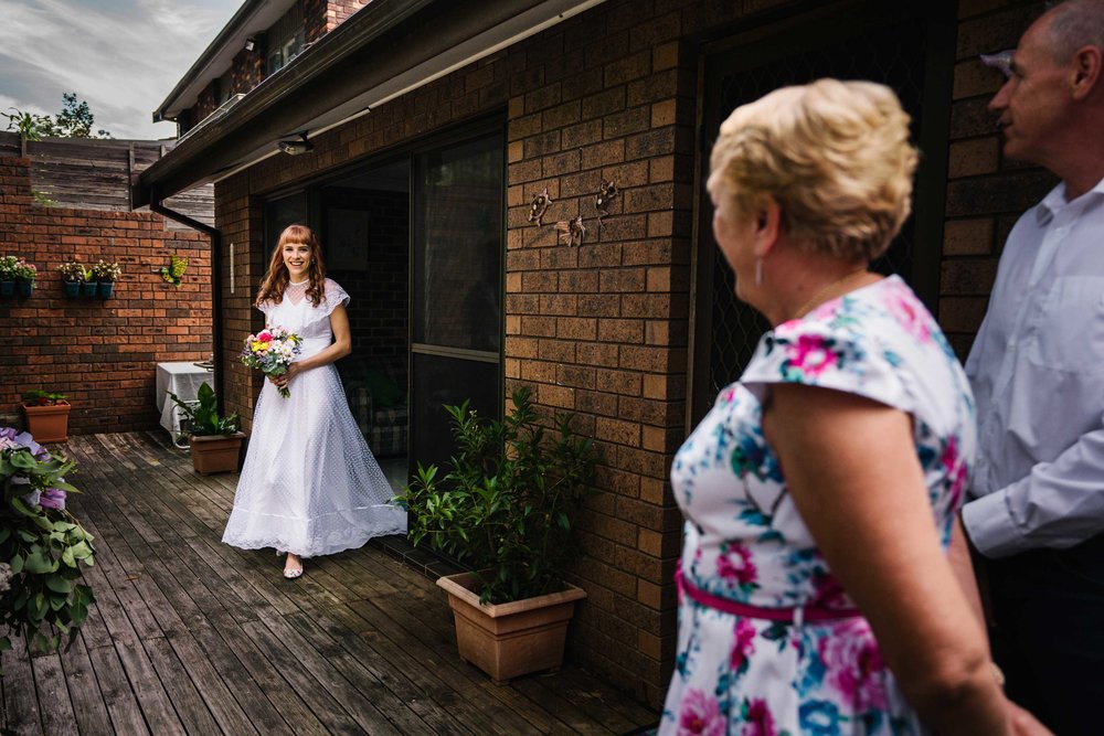 Bride in vintage wedding gown enters garden ceremony