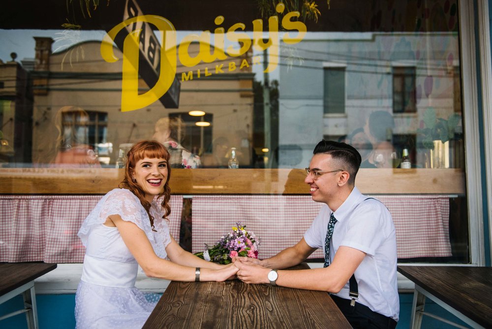 Couple holding hands in front of Daisy's Milk bar in Petersham NSW