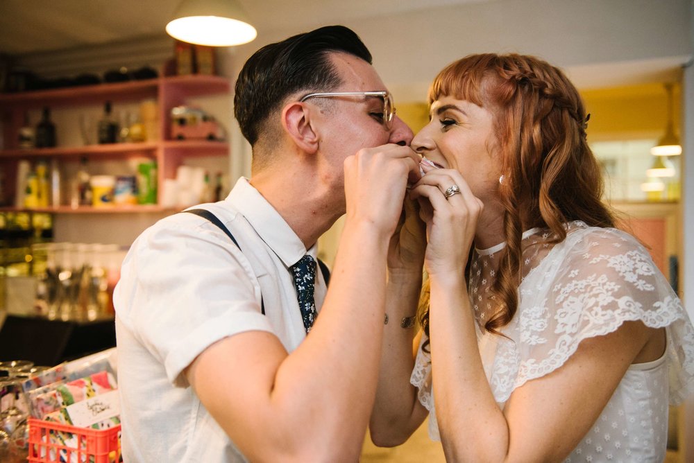 Newlyweds eating donut wedding cake