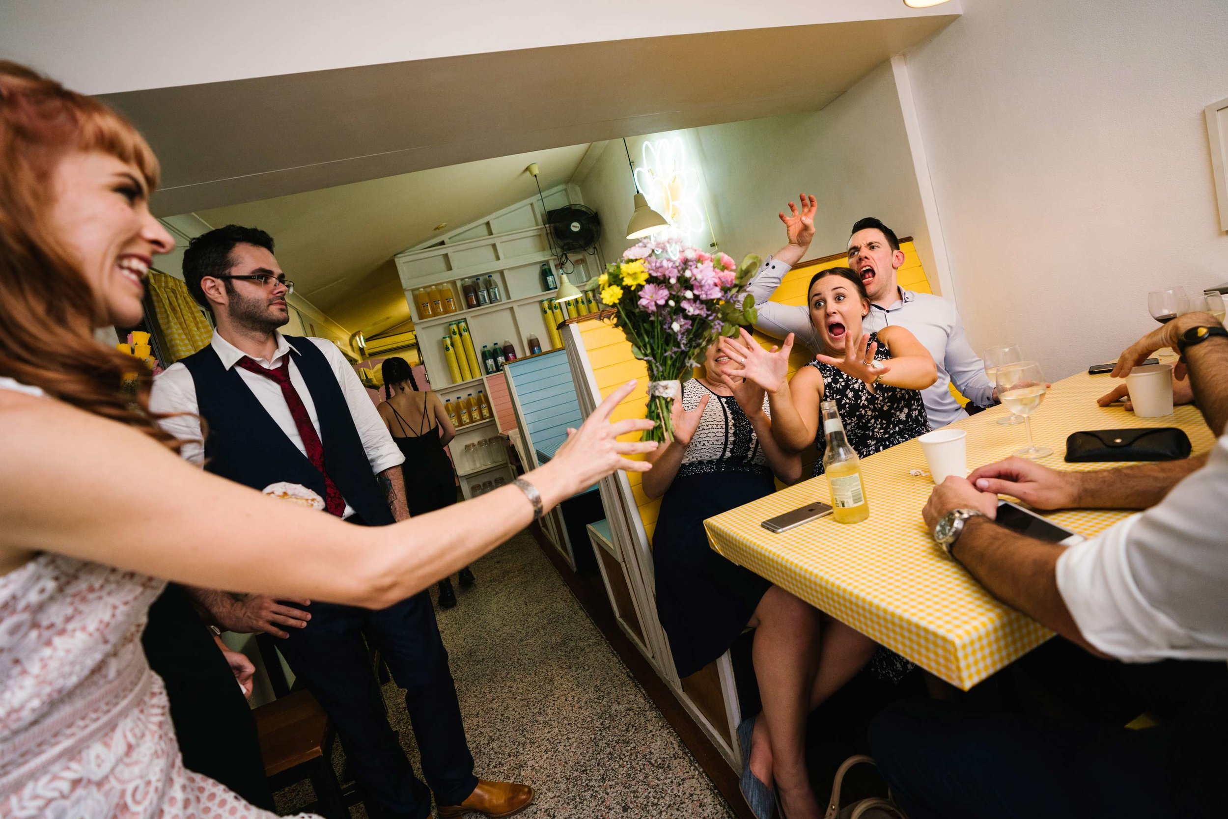 Bouquet toss at quirky milk bar wedding reception