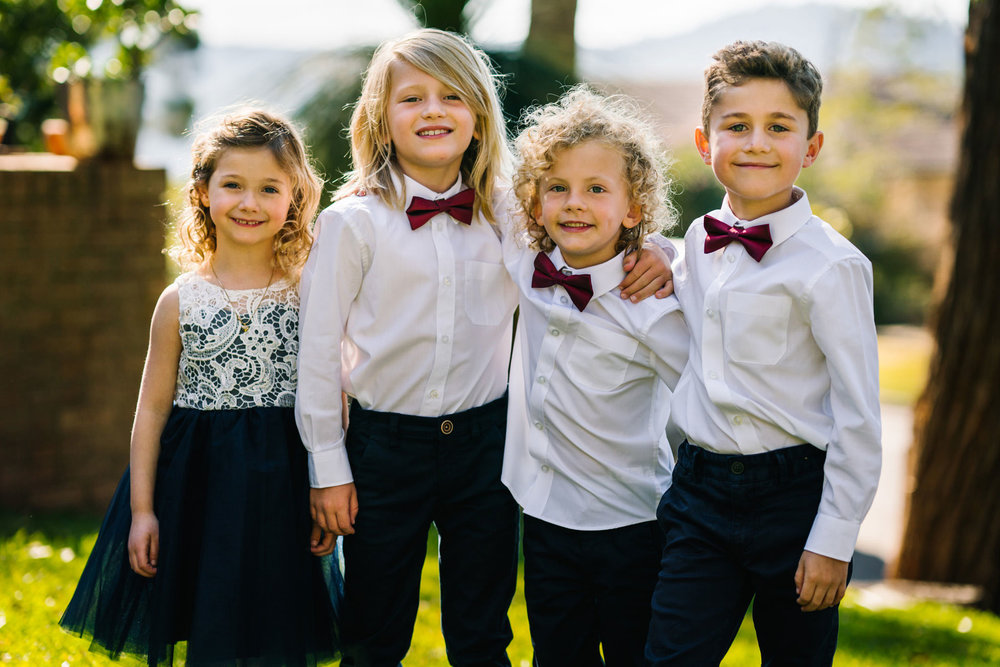 Flower girl and pageboys in bowties smiling