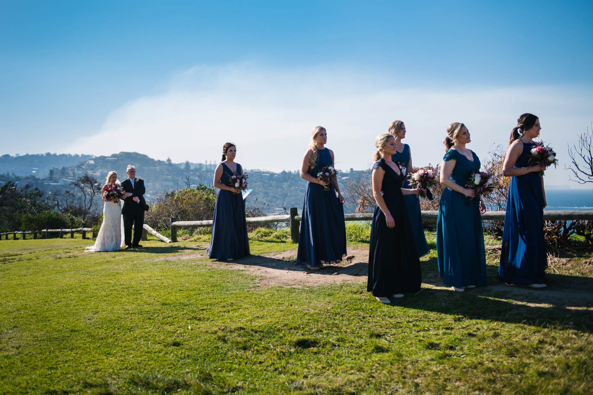 Bride, father and bridal party approaching the ceremony on Mona Vale headland