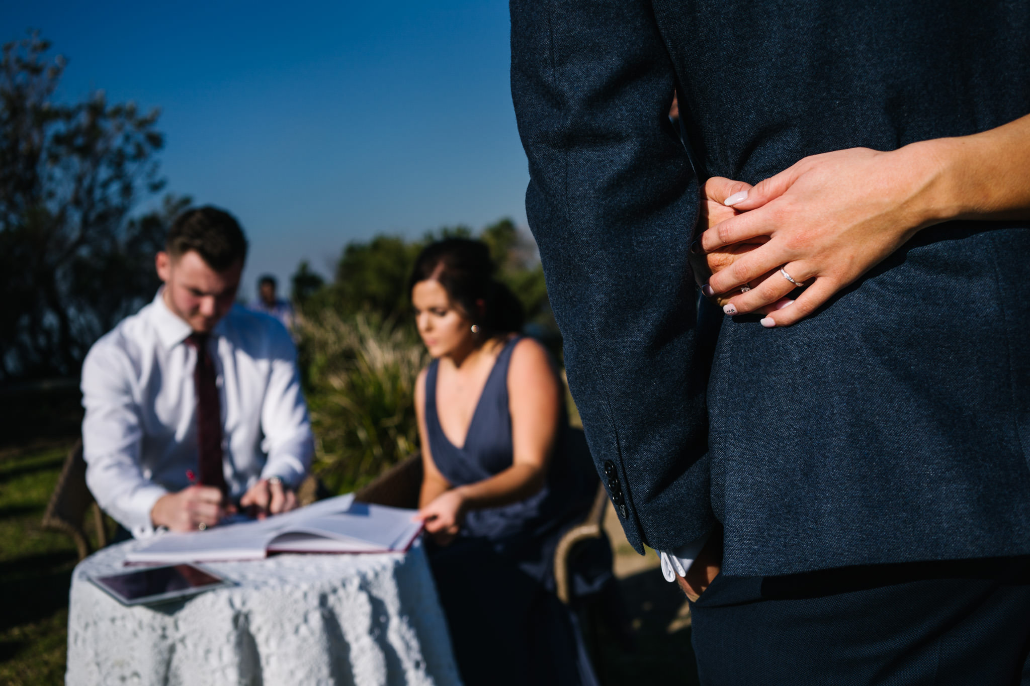 Bride and groom embrace during document signing