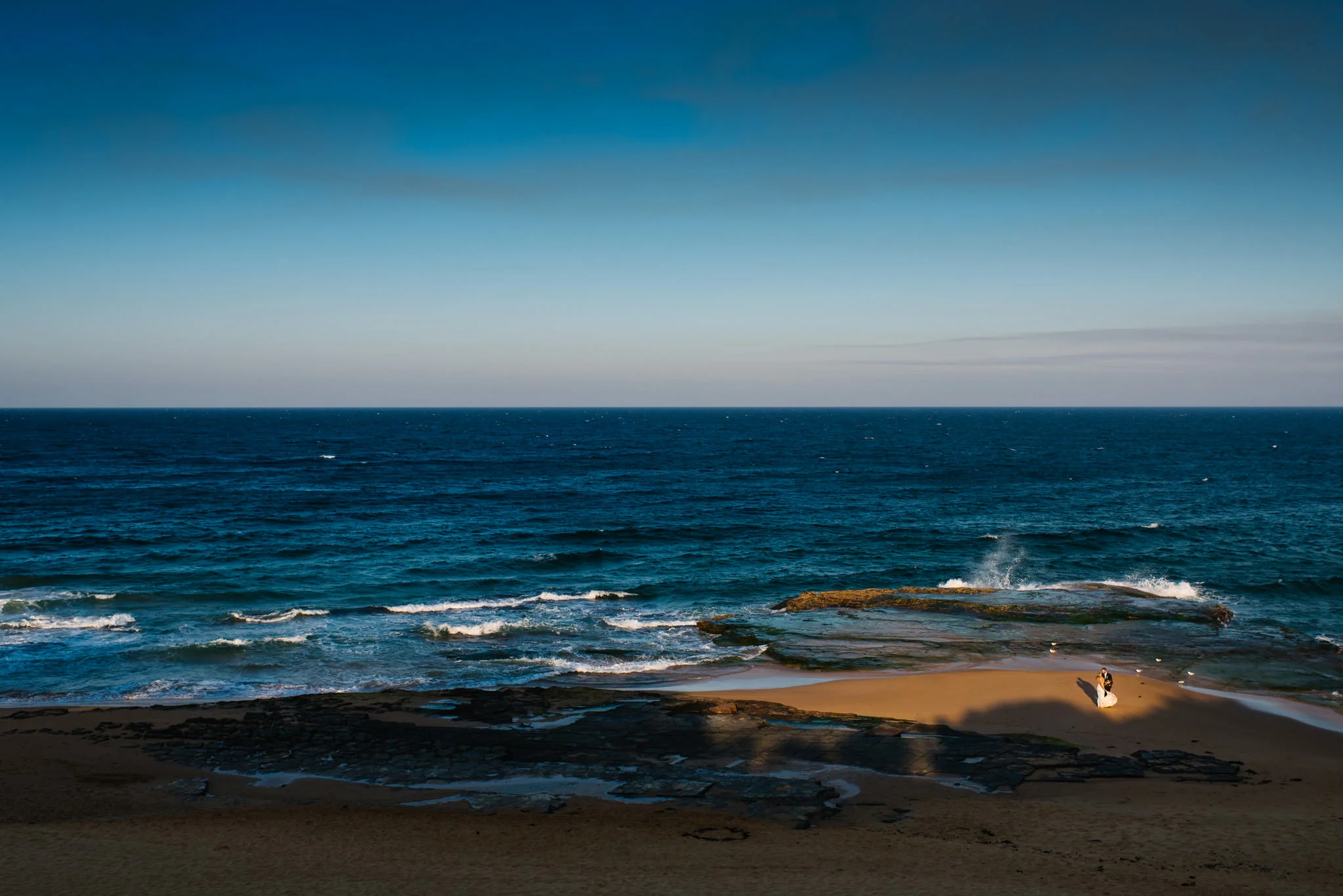 View of bride and groom on Turimetta beach