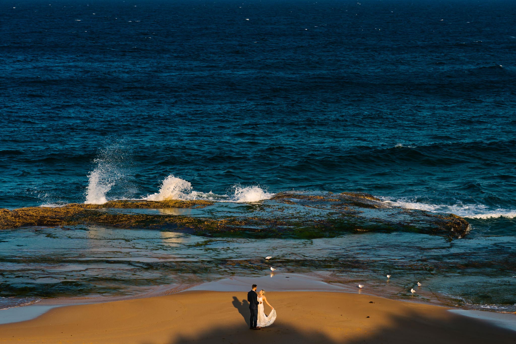 Bride and groom embracing on Turimetta beach in the Northern Beaches of Sydney