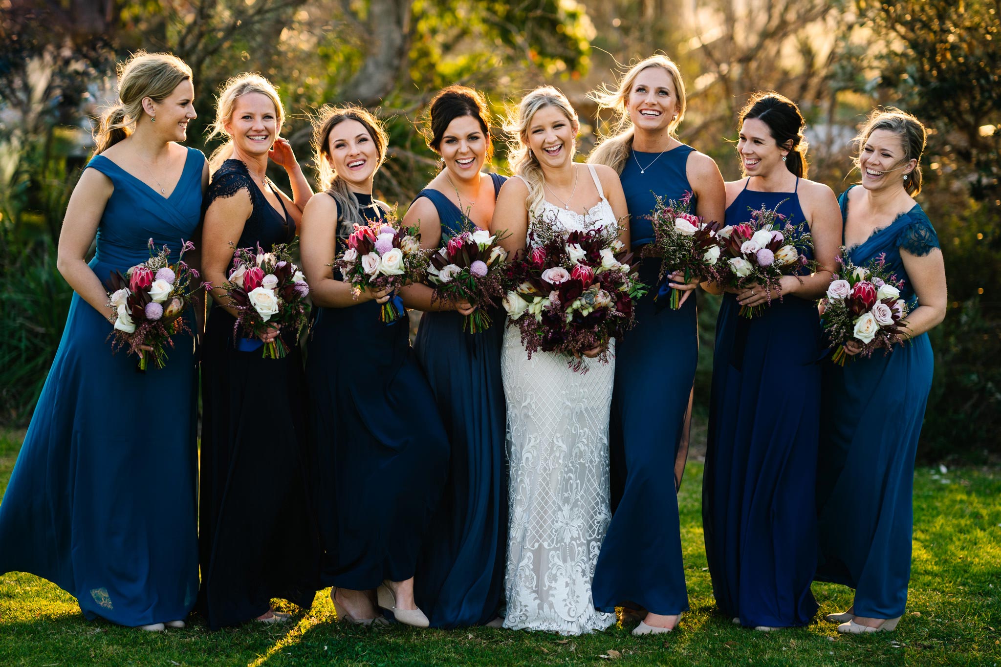 Bride with bridesmaids laughing at groomsmen
