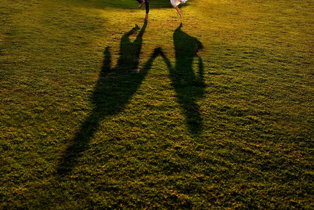 Shadow of bride and groom as they jump in the air