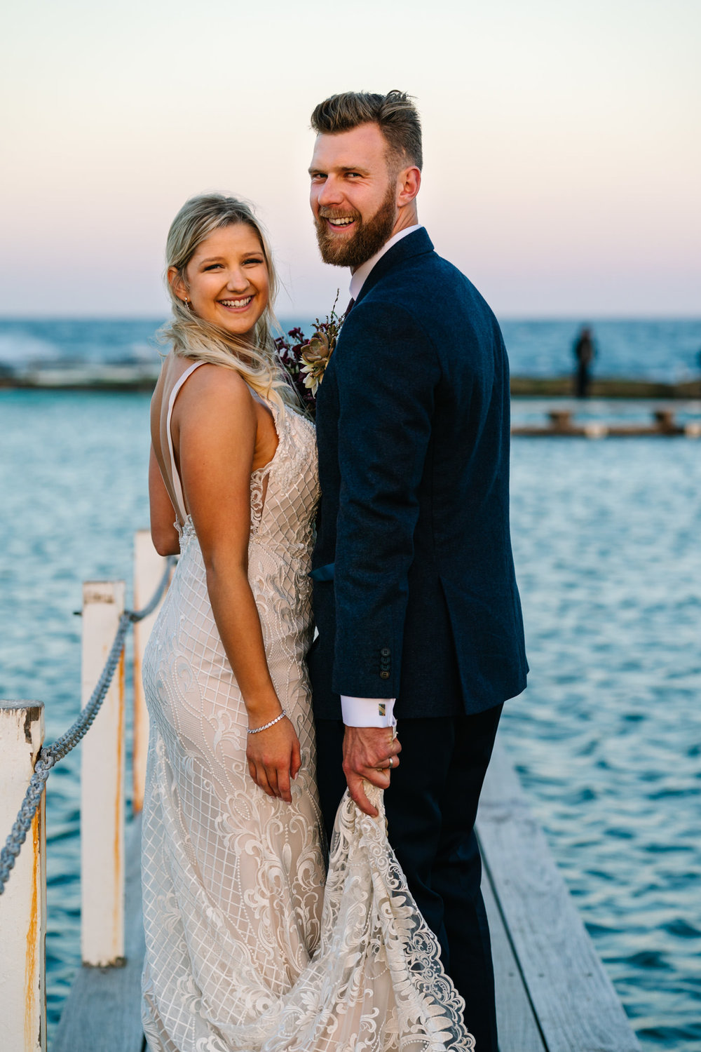 Bride and groom smiling at Narrabeen pool