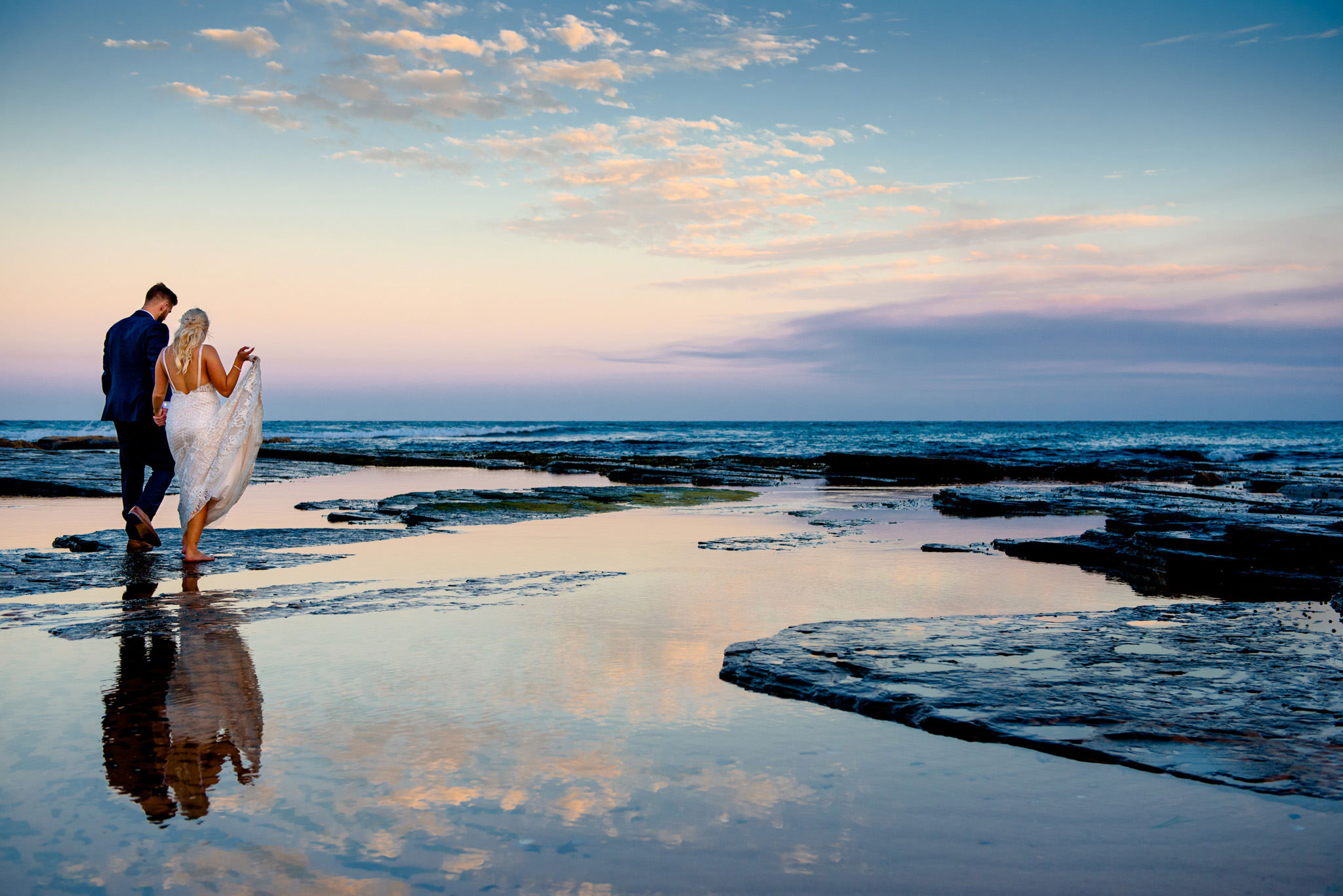 Reflection of bride and groom in water at Narrabeen beach