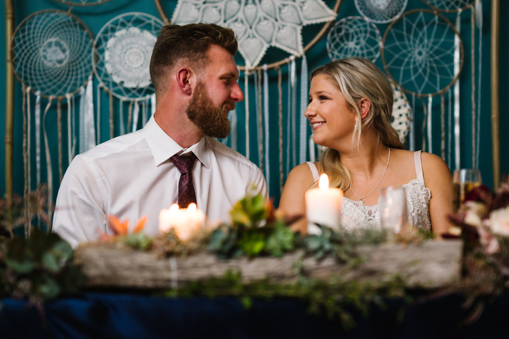 Bride and groom smiling at each other during speeches