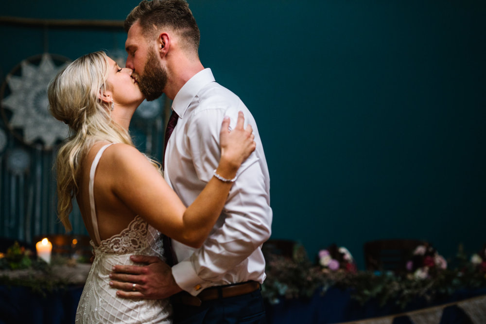 Newlyweds kiss during their first dance at Narrabeen Beach SLSC reception
