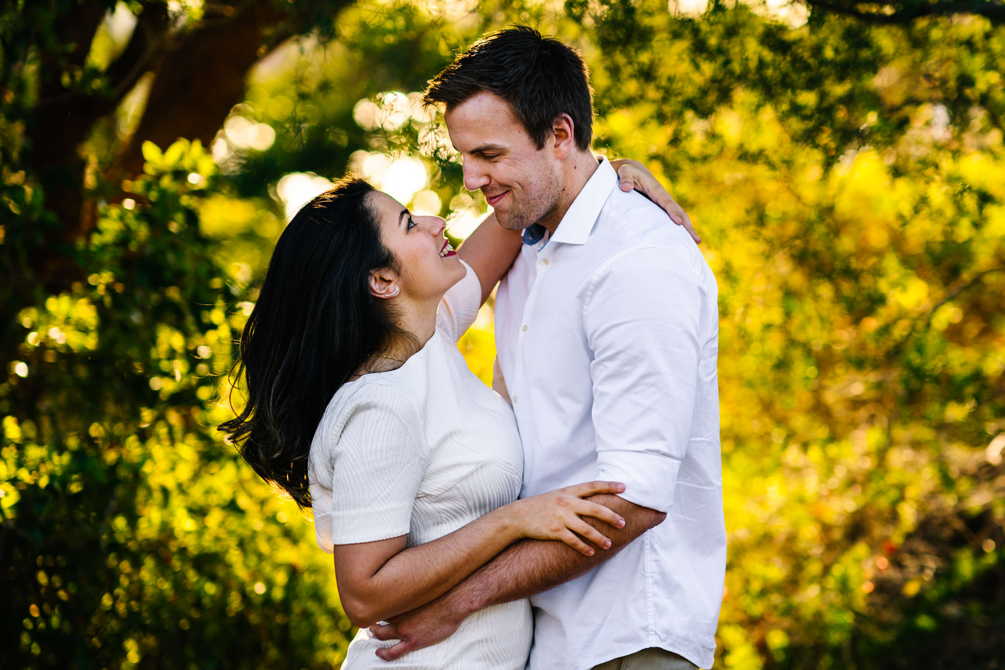 Engaged couple smile lovingly at each other during Sydney engagement session