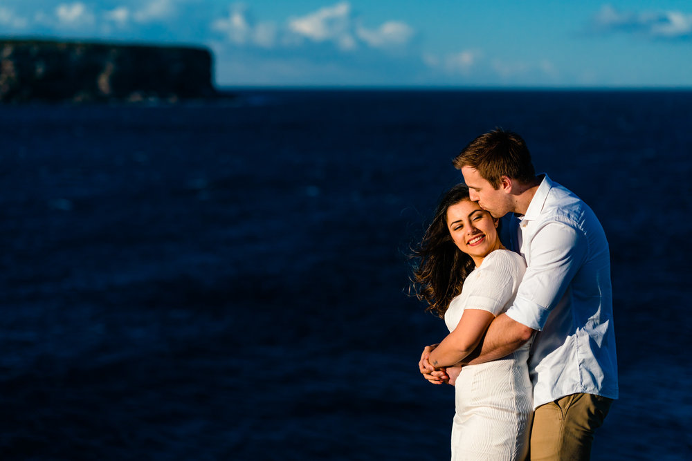 Couple embrace with views of the Sydney harbour in the background