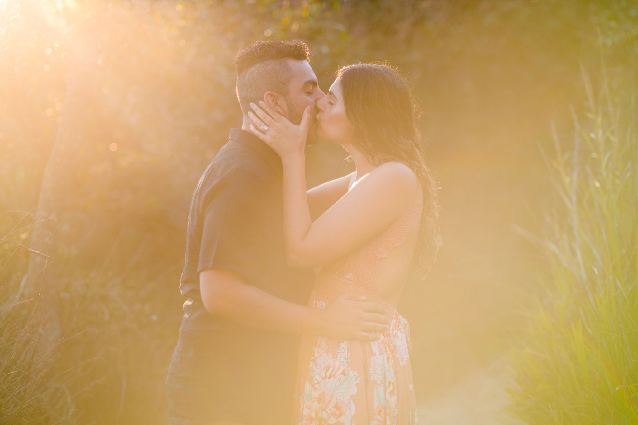 Couple kissing with backlight and sun flares around them