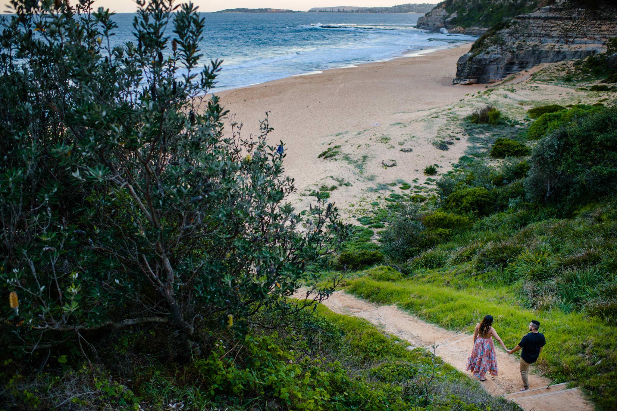 Couple walking down stairs to the beach in Sydney's Northern Beaches