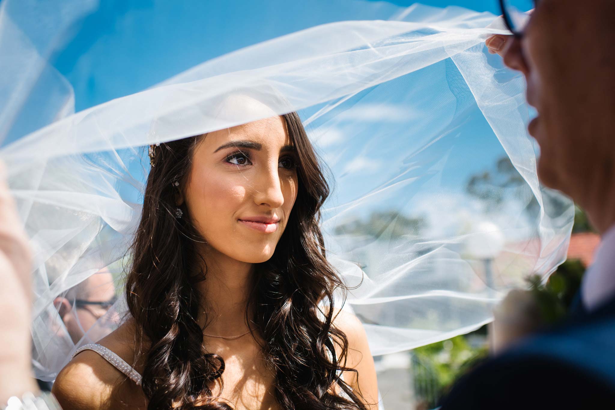 Bride's father lifts veil over bride's head