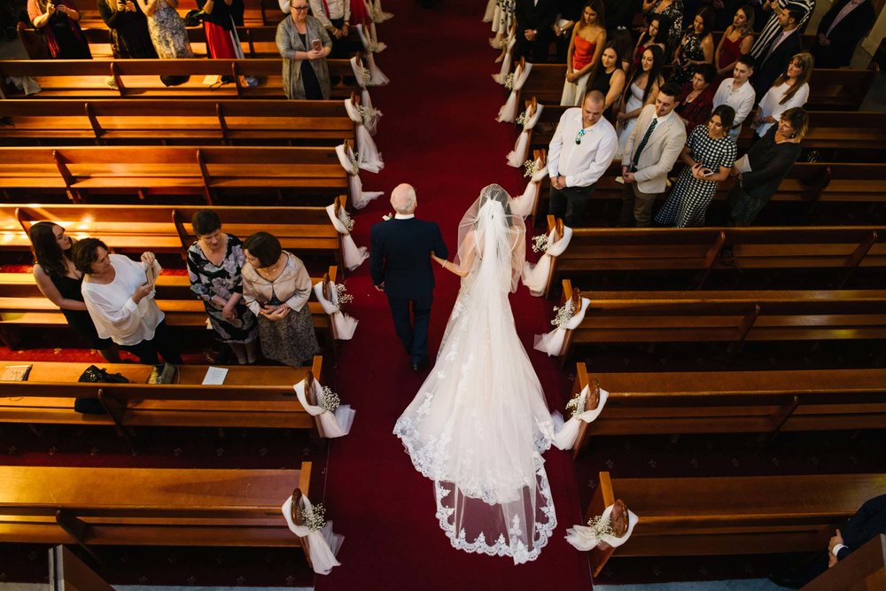 Birds eye view of bride and father entering the church