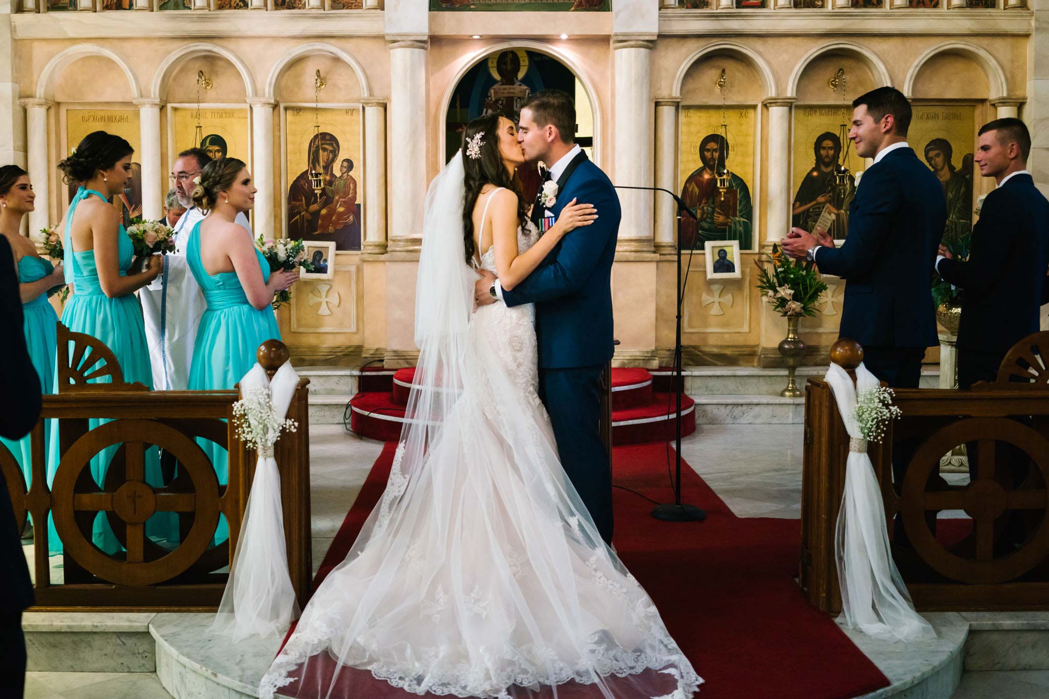 Bride and groom's first kiss during Greek orthodox wedding ceremony