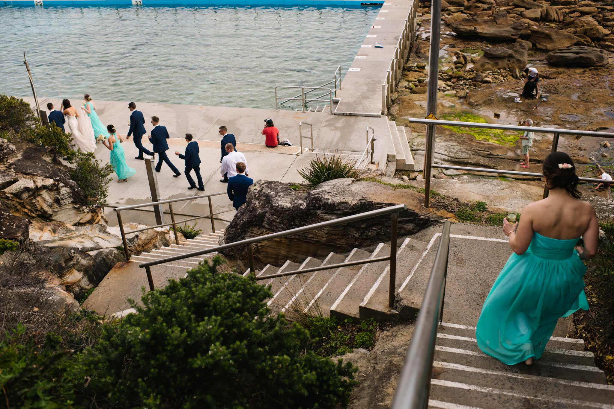 Bridal party walking down the stairs towards the tidal pool at Freshwater beach