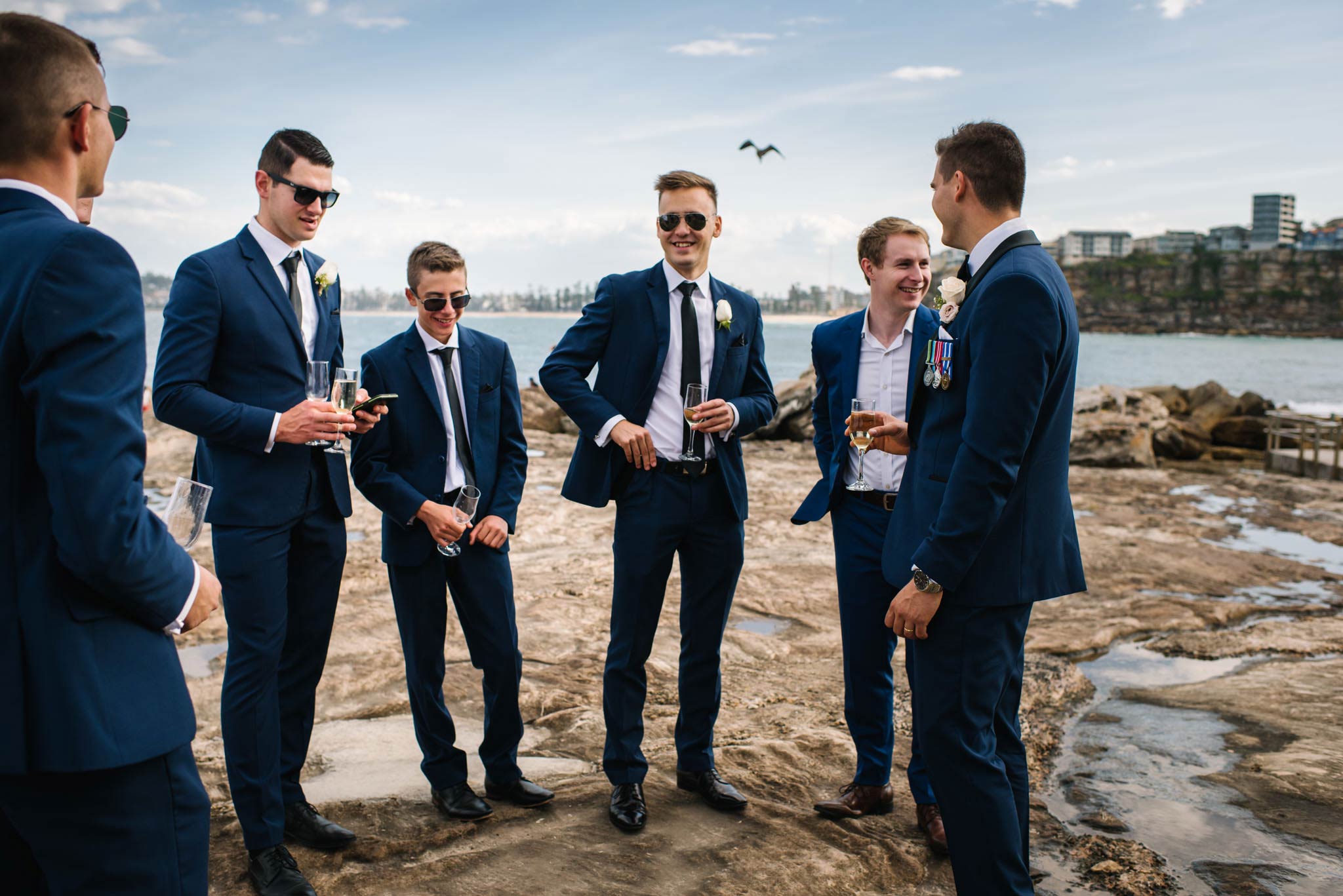 Groomsmen casually chat with Freshwater beach in the backdrop