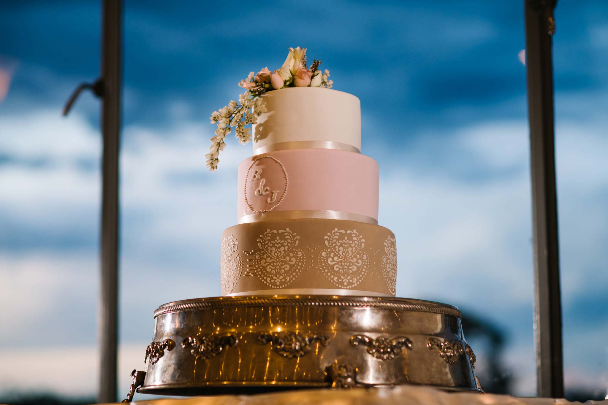 Three tier pink, gold and cream wedding cake