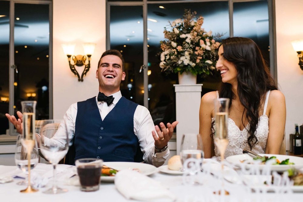Bride and groom laughing at speeches