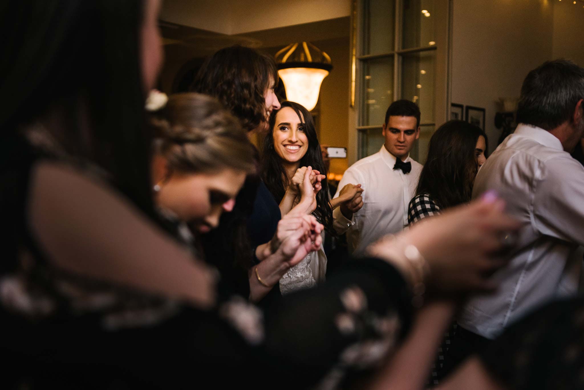 Bride having fun during Greek circle dancing at wedding reception