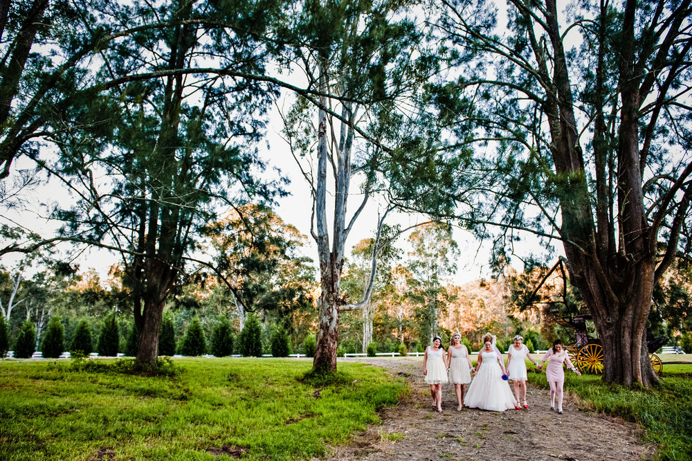 Bridesmaids and bride walking through gardens at Redwood Park