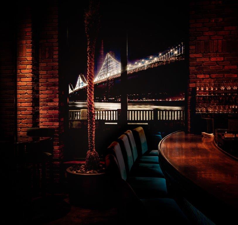 Photo of dining table at night with stunning view of Bay Bridge in background