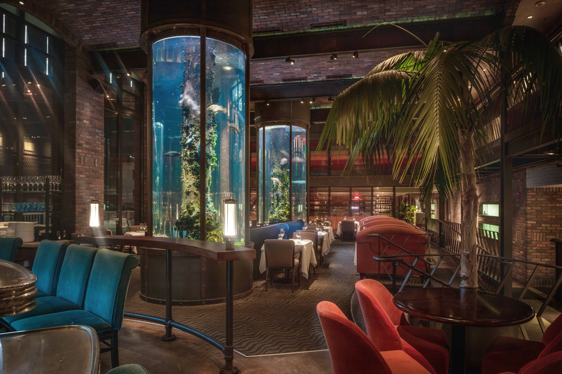 Photo of main dining room at Waterbar featuring our two floor to ceiling cylindrical aquariums.