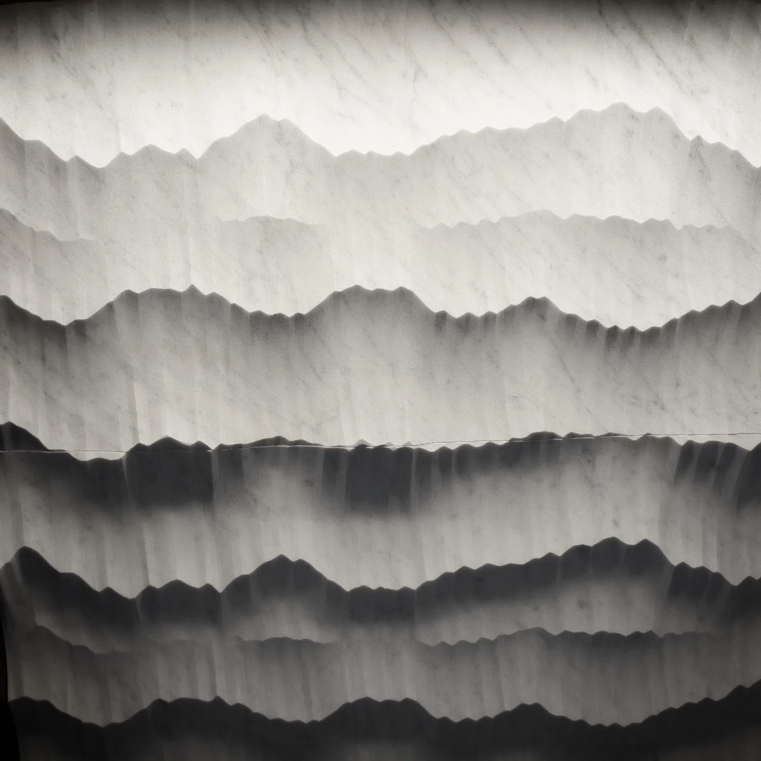 Machined, but random texture creates shadows that reveal a mountain landscape. Hedonism collection by Petra Antiqua