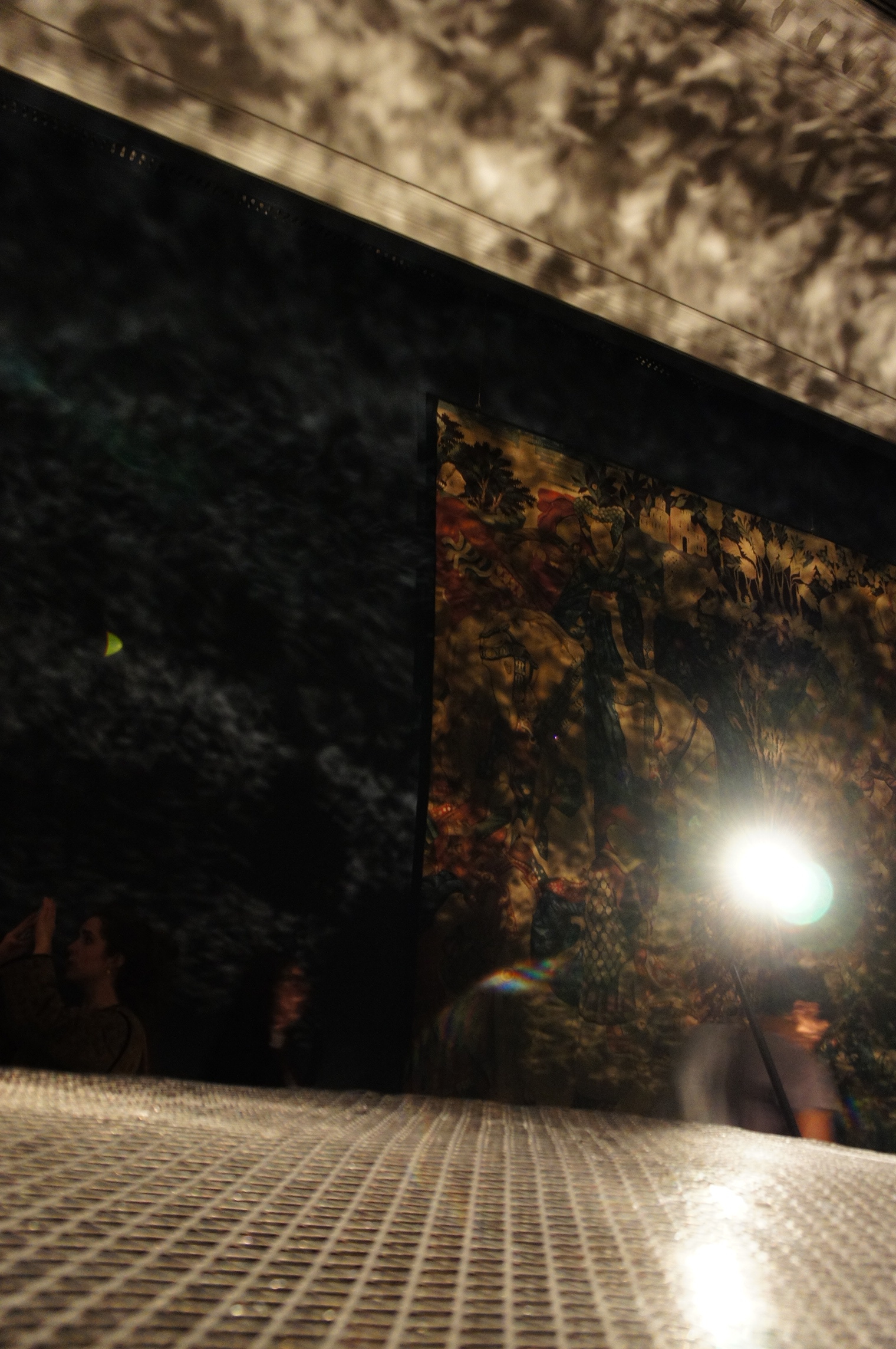 Gently undulating mirror near chest height casts reflections in the room. "Foil" exhibition at V&A