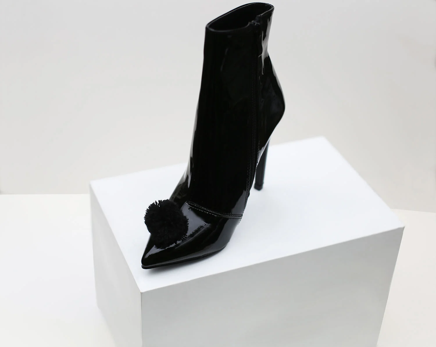 Black-patent-ankle-boot-with-pom-pom.jpg