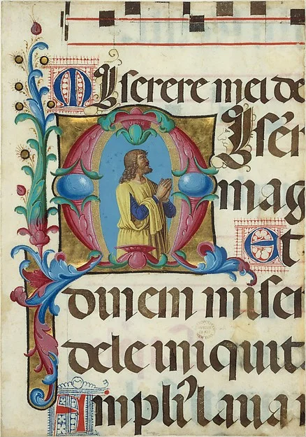 Photo: Manuscript Illumination with David in Prayer in an Initial M, from a Psalter Artist: Girolamo dai Libri (Italian, Verona 1474–1555 Verona), Date: 1501–2. "Like the singing monks in Girolamo dai Libri's miniature executed for the same psalter (displayed nearby), David appears here in prayer with his mouth open and his gaze turned heavenward. In many images of David, God the Father appears above him as the object of his inspiration. Like the monks, he appears to look beyond the frame of the initial, as if he were reading the text of the psalter." To learn more about this piece, see: The Metropolitan Museum of Art