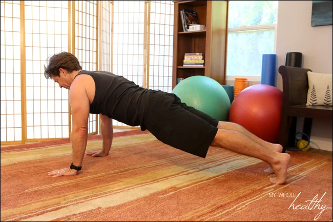Plank done in a push-up position. If this is too difficult, it can also be done from the knees with the feet lifted off the floor. In either position, imagine a straight line running from the top of the head, through the neck, down the spine and through the tailbone. If on your toes as pictured, extend that line through your legs to your feet. If on your knees, the straight line would end at your knees on the floor.